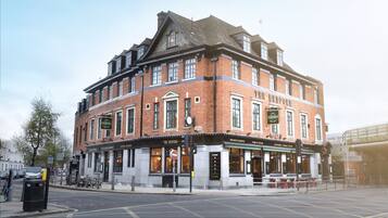 Un edificio histórico con varios locales comerciales en la planta baja, incluyendo un hotel, un espacio para eventos privados y un pub.