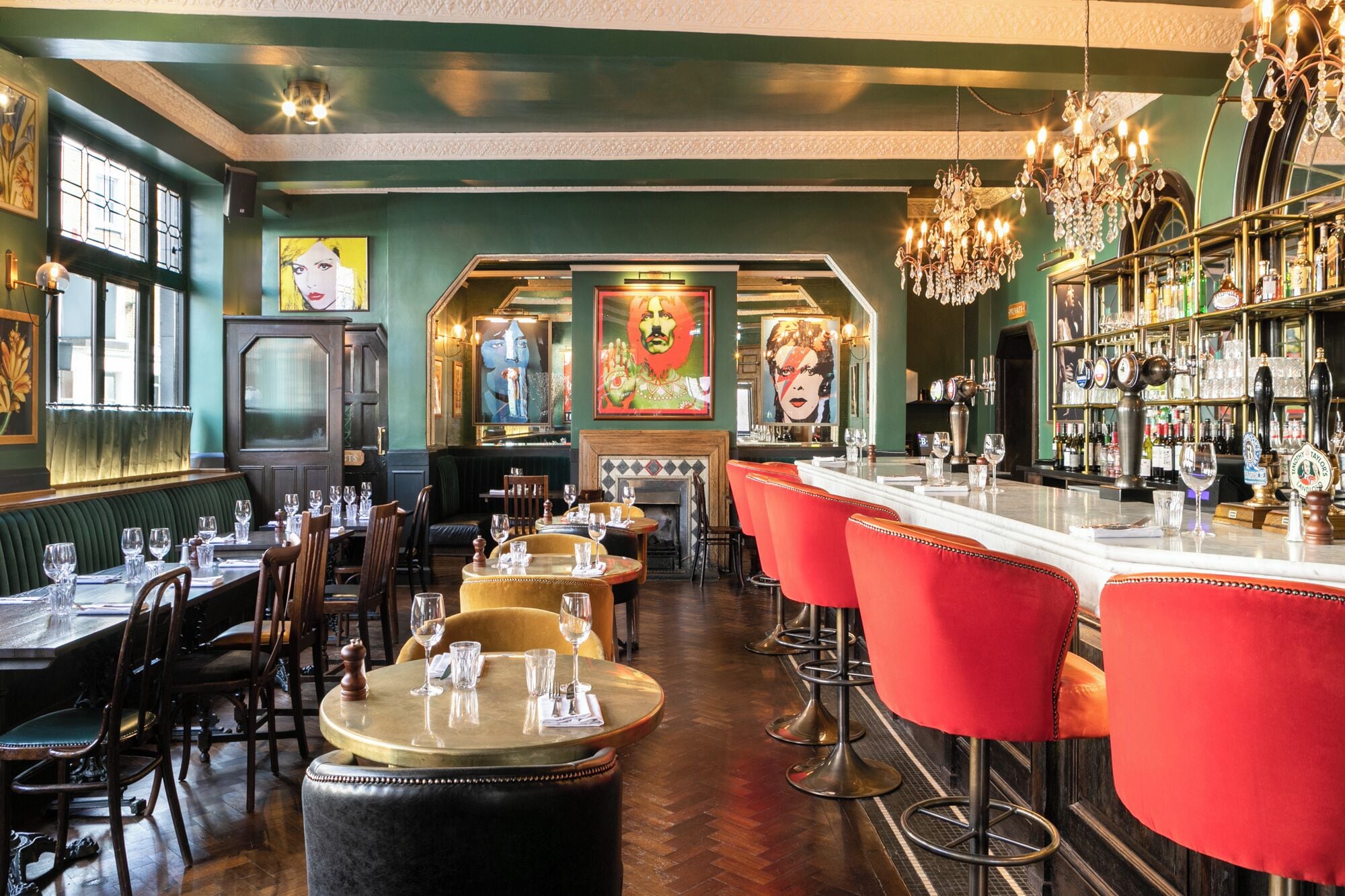 A bar area with multiple stools, a bar counter, and a variety of bottles.