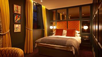 Una habitación de hotel con una cama grande, dos lámparas de noche, un ventanal con cortinas y una obra de arte en la pared.