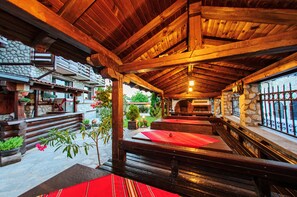 Un intérieur rustique avec des murs en pierre, des bancs en bois et une cheminée en pierre.