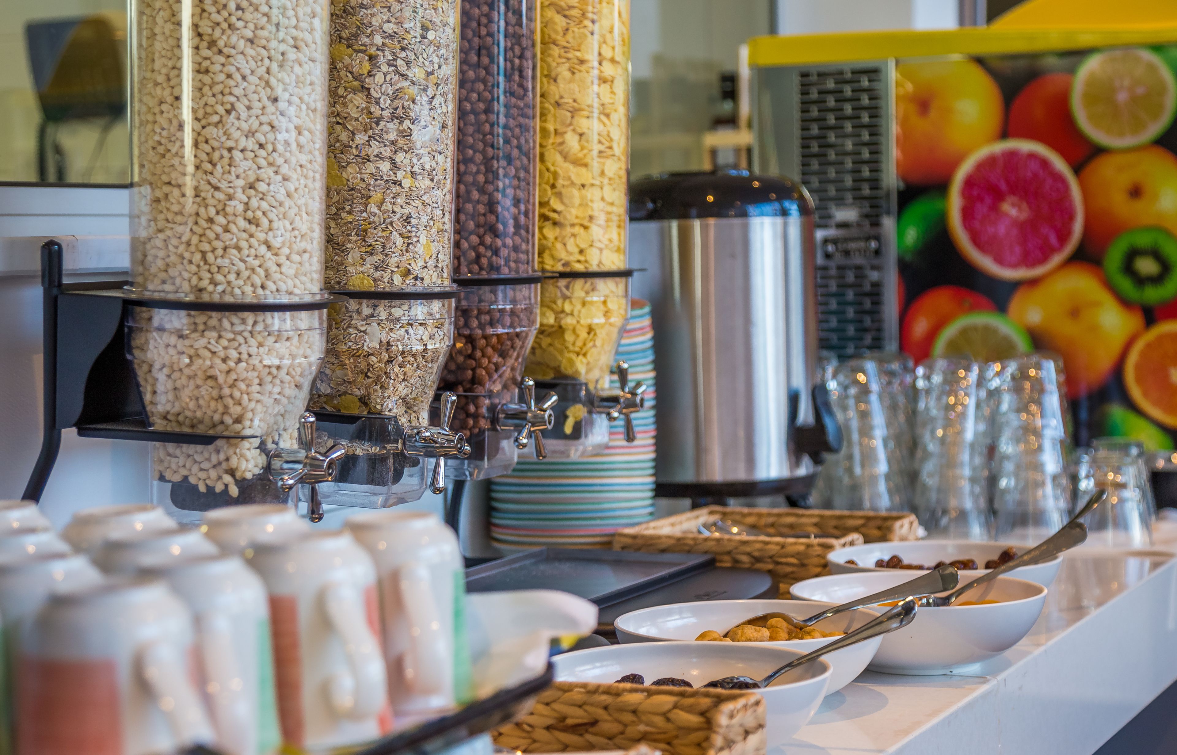 A buffet with various food dispensers, including nuts and grains.