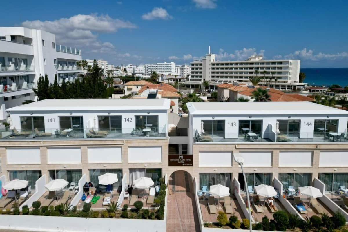 Un hotel con varios pisos, zonas de estar al aire libre y vista al mar.