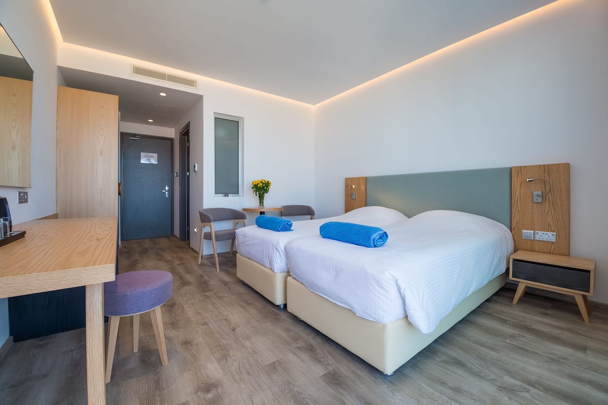 Una habitación de hotel moderna con una cama grande, un escritorio y una silla.