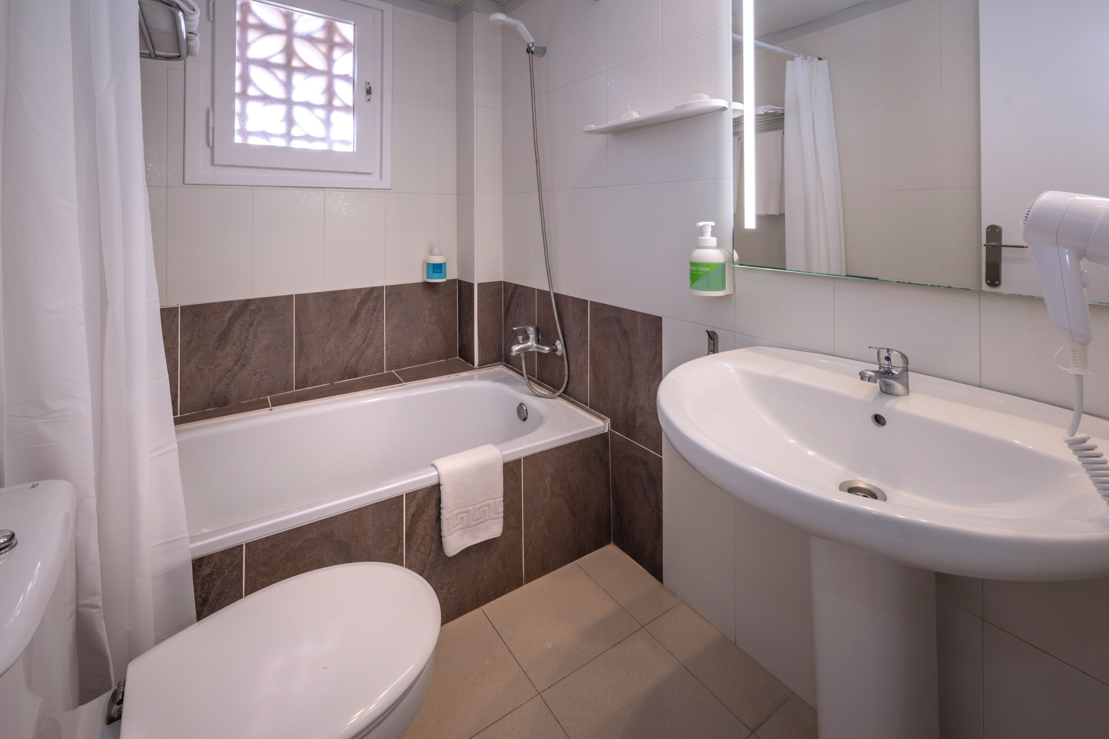 A bathroom with a bathtub, toilet, and sink.