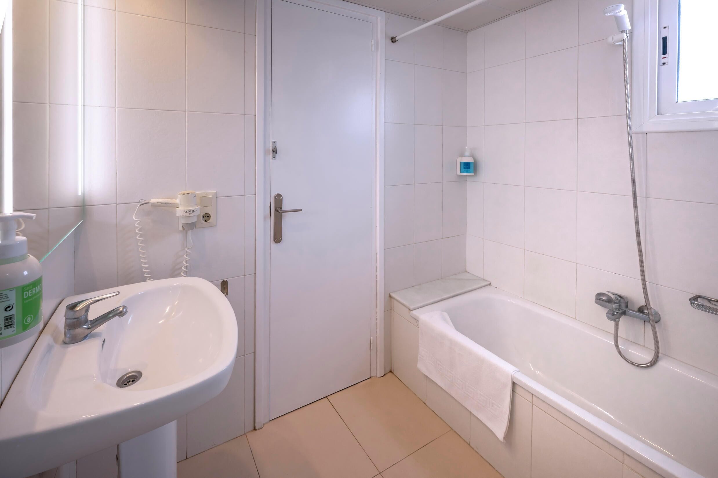 A bathroom with a white sink, a bathtub, and a shower.