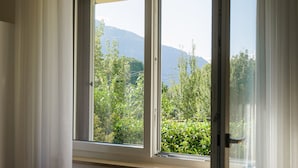 A window with a view of greenery and mountains. - B&B L'Albero Maestro (Borgofranco d'Ivrea)