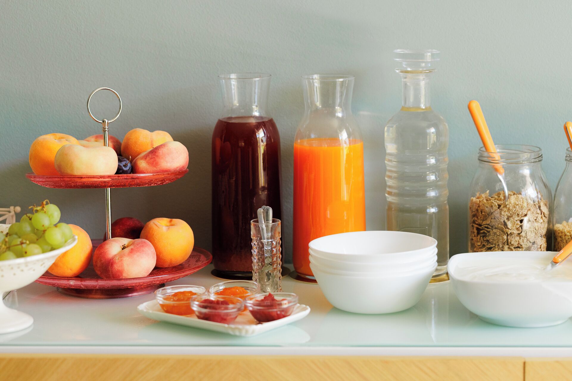 A breakfast table with fruits, beverages, and breakfast items.