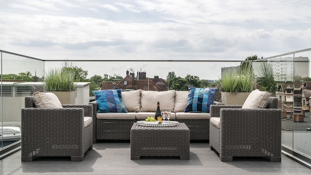 A rooftop terrace with wicker furniture, a glass table with a bottle and glasses, and a city view. - Sanhaus Apartments - Parkowa (Sopot)