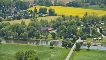 Zona rural con un río, campos y un pequeño grupo de casas.