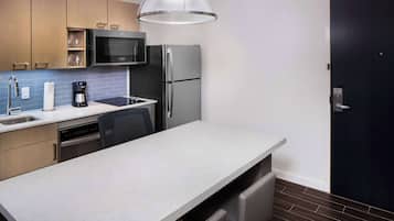 Una cocina moderna con microondas incorporado, refrigerador de acero inoxidable y una isla grande con pileta.