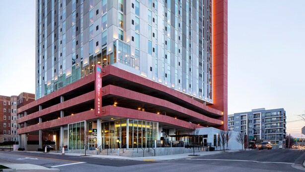 A multi-story hotel with a modern design, featuring a prominent red vertical element on the right side.