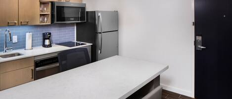 A modern kitchen with a built-in microwave, refrigerator, and dishwasher.