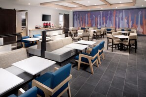 A modern restaurant with booths, tables, and a counter area. - Hyatt House Nashville at Vanderbilt (Nashville)