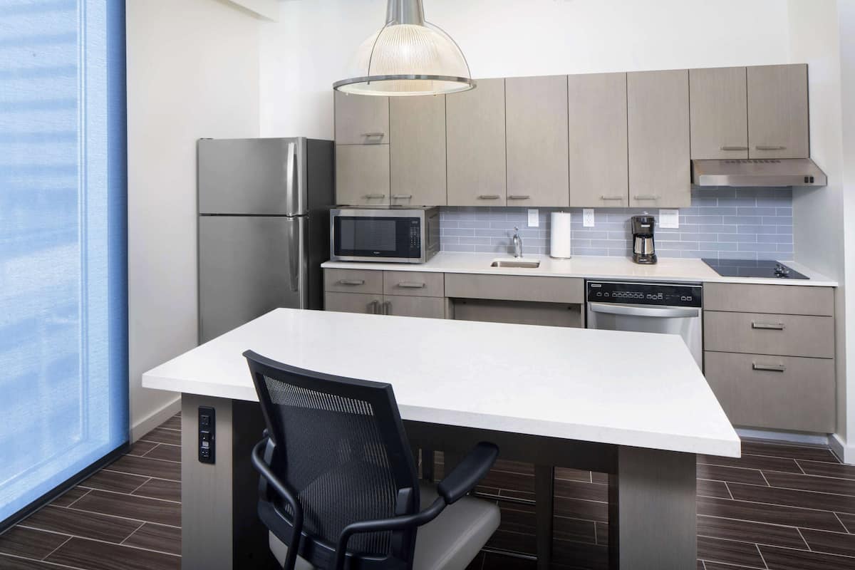 A modern kitchen with a built-in microwave, refrigerator, and dishwasher.
