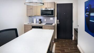 A compact kitchen with a microwave, coffee maker, and dishwasher.
