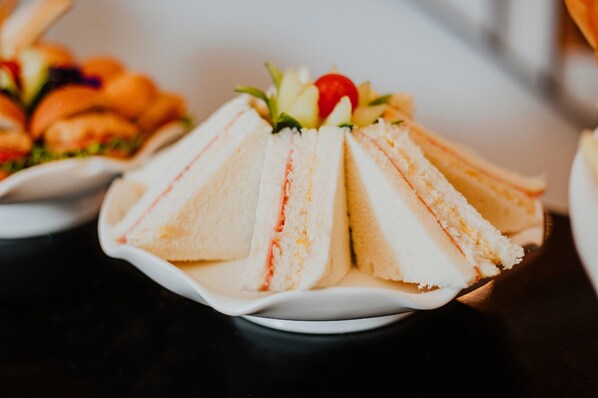 A plate of sandwiches with a decorative cherry on top. - Nobility Grand Hotel (Lima)