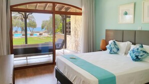 Habitación de hotel con cama, televisión y vistas a una piscina y zonas verdes.