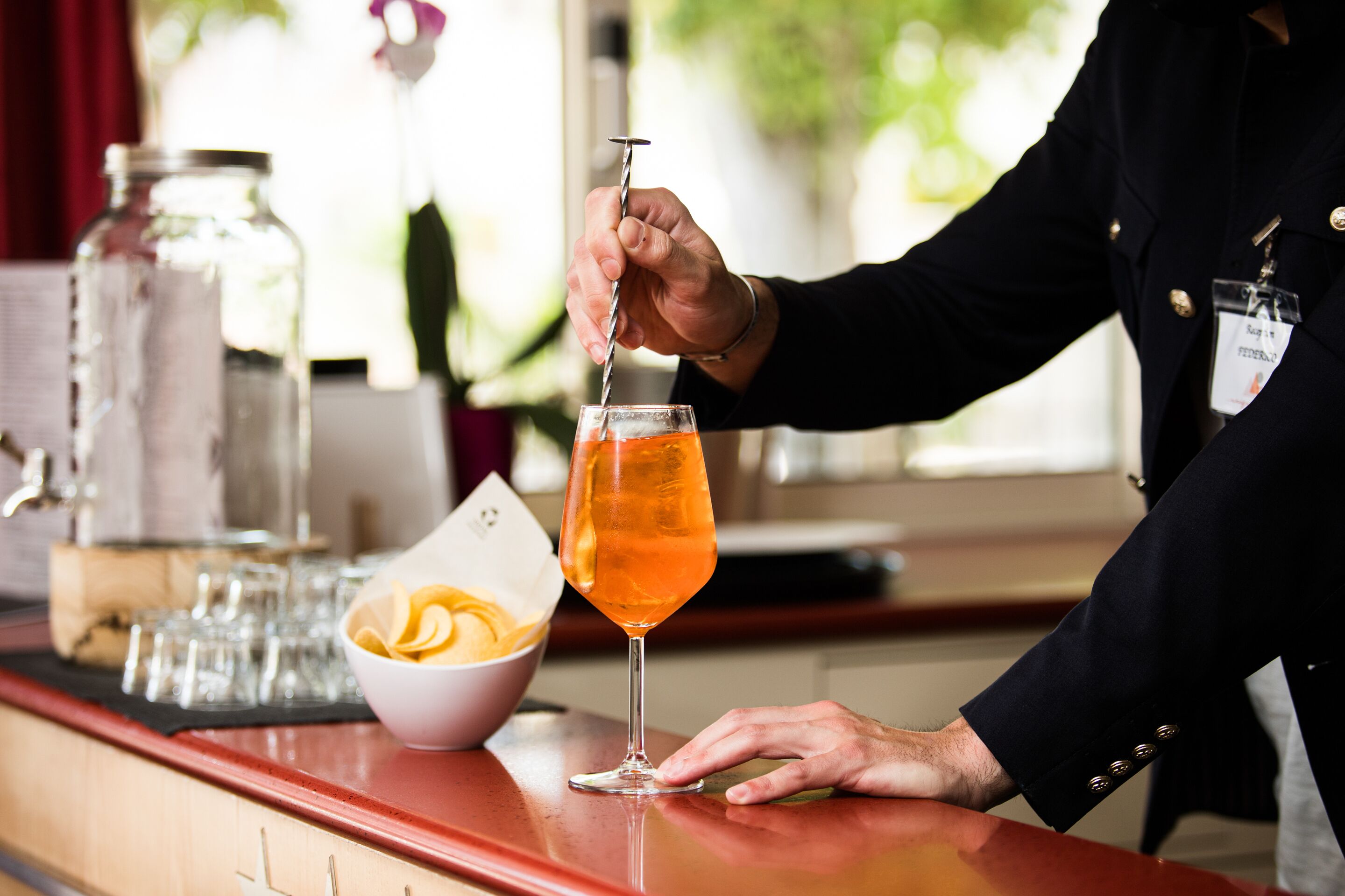 A bartender pouring a drink into a glass.