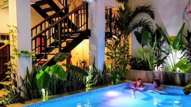 Un espace piscine avec un panneau indiquant « Bona Vida Hostels ».