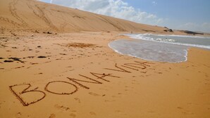 Une plage où le mot « BONAVIDA » est écrit dans le sable.
