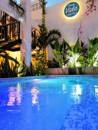 Una piscina al aire libre, sillones reclinables de piscina
