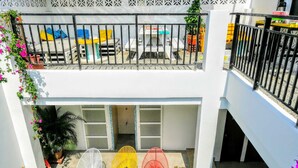 Un bâtiment à deux étages doté d’un balcon, d’une piscine et d’un espace extérieur aménagé pour s’asseoir.