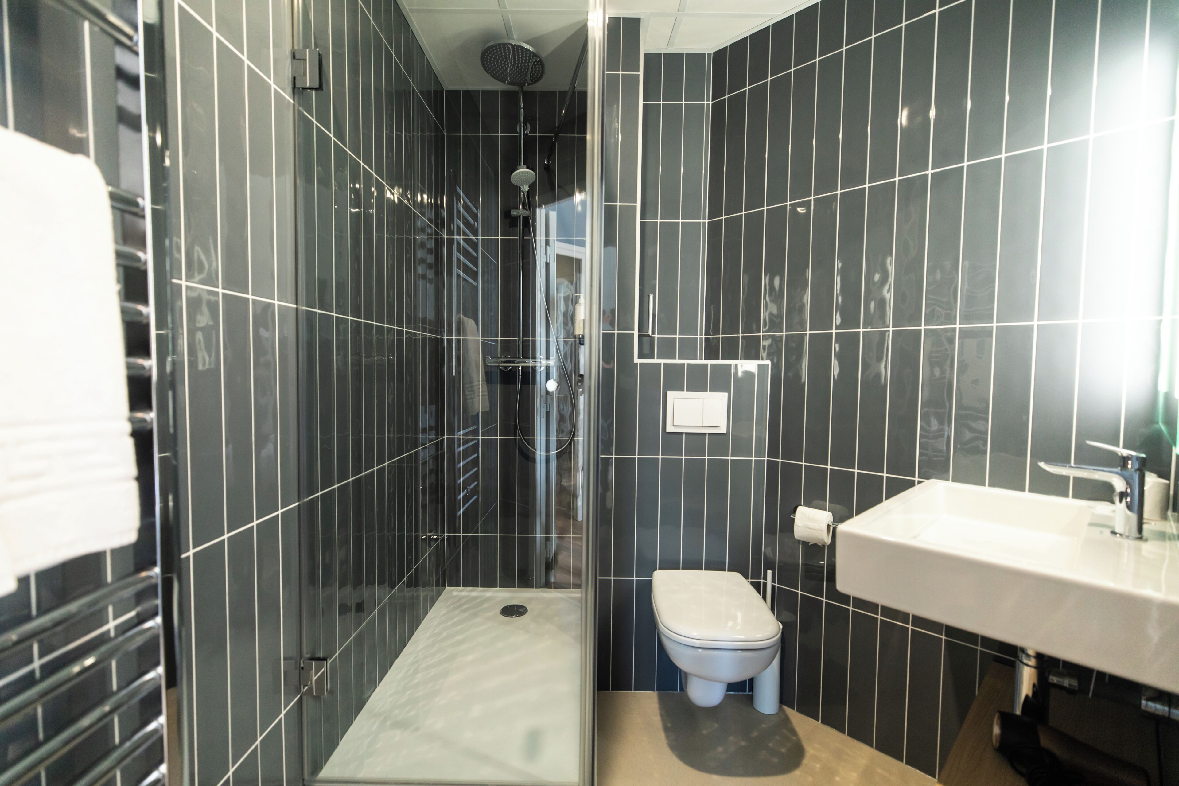 A bathroom with a shower, toilet, and sink.