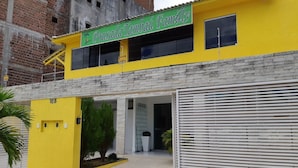 A yellow building with a sign reading "Pousada Tambáu Family". - Pousada Tambau Familly (João Pessoa)