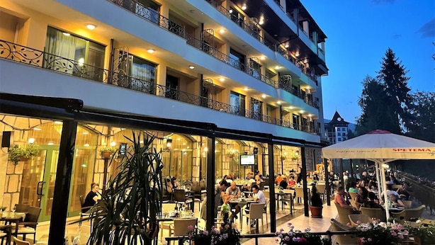 Un hôtel à plusieurs étages doté d’espaces de restauration en plein air et de balcons.