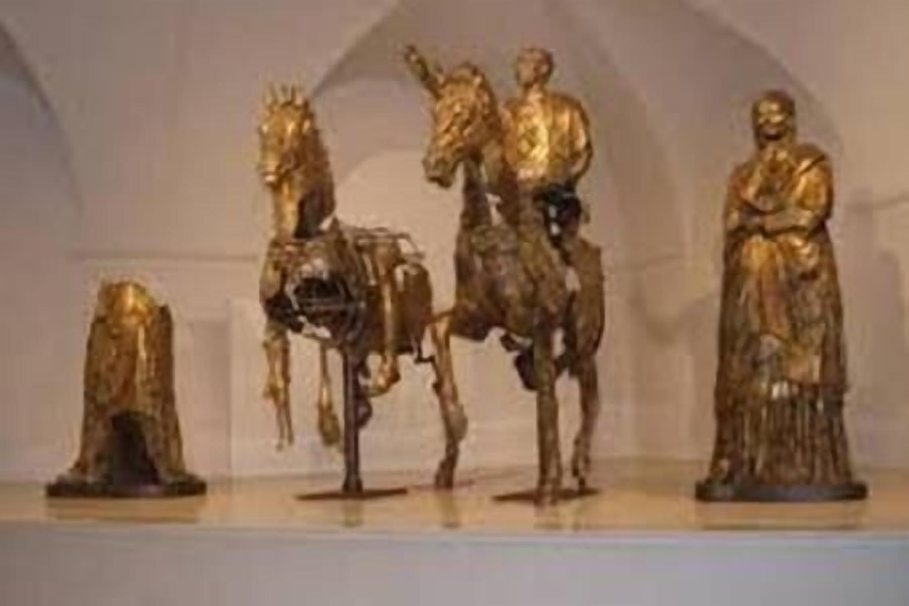 Une collection de statues dorées, comprenant un cheval et une figure humaine, exposées sur une étagère.