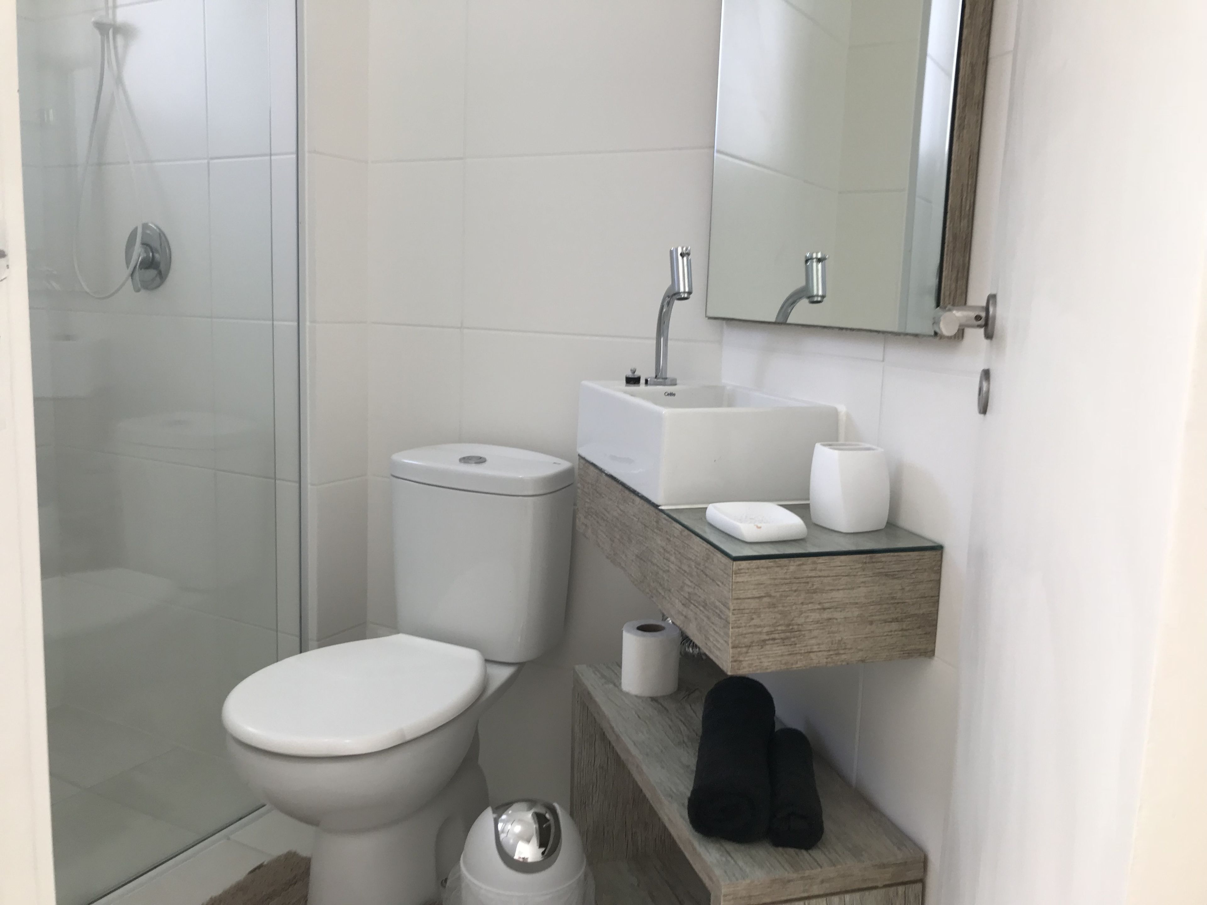 A modern bathroom with a toilet, sink, and shower.