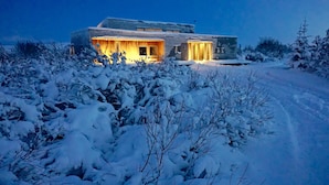 A modern house with a large porch and a snow-covered landscape. - Luxury House with a Cozy Guesthouse + Hot Tub close to Snæfellsnes National Park (Borgarnes)