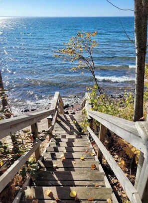 A wooden staircase leading to a beach with a view of the ocean.