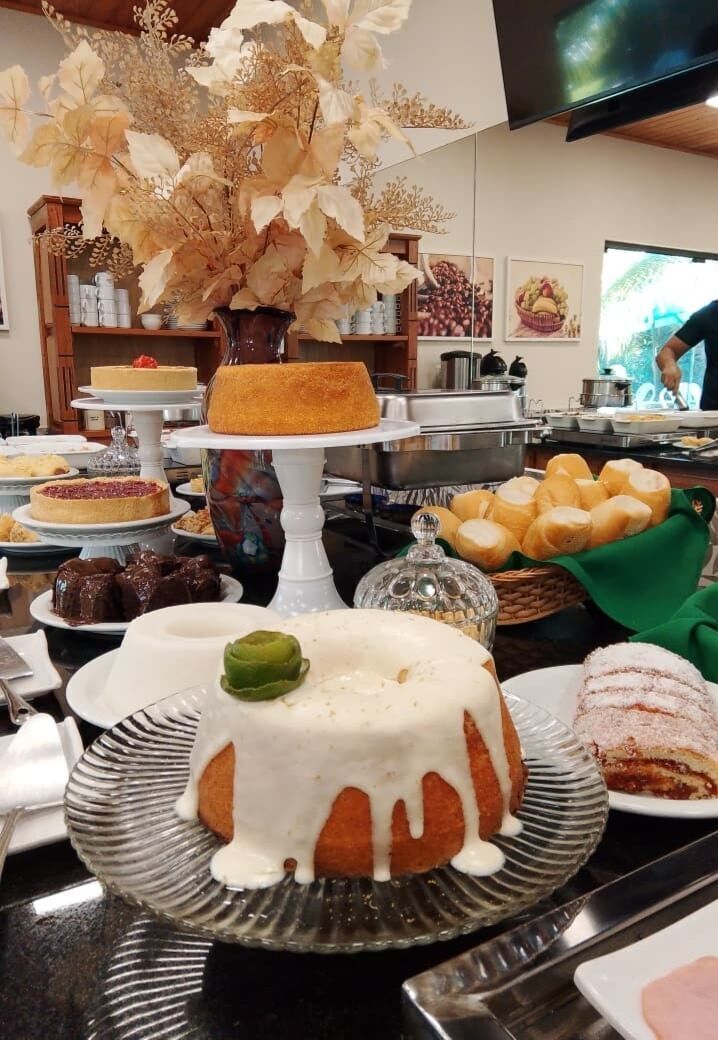 Una mesa de bufé con diversos postres y una pieza central decorativa.