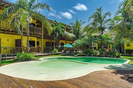 Una piscina al aire libre, sombrillas, sillones reclinables de piscina