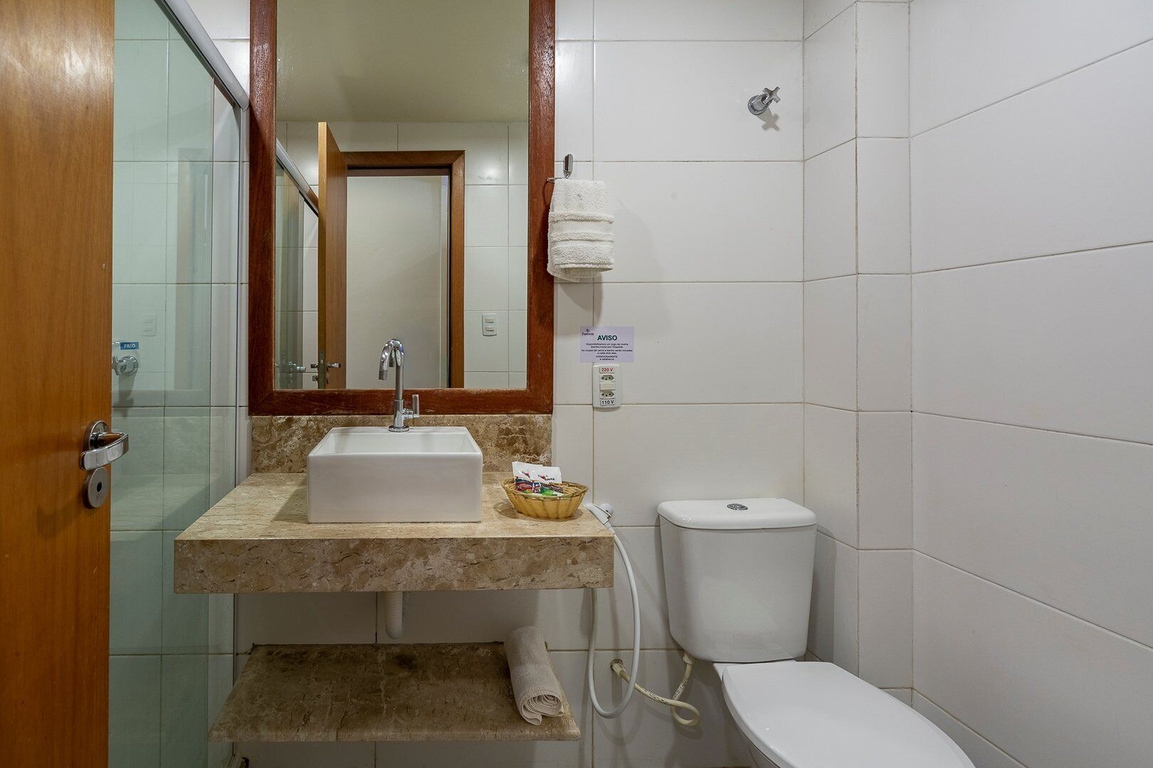 Ein Badezimmer mit Waschbecken, Toilette und Spiegel.
