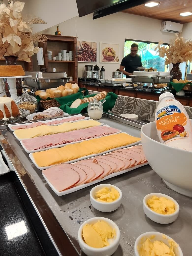 Montaje de bufé con diferentes alimentos y un chef preparando comida.