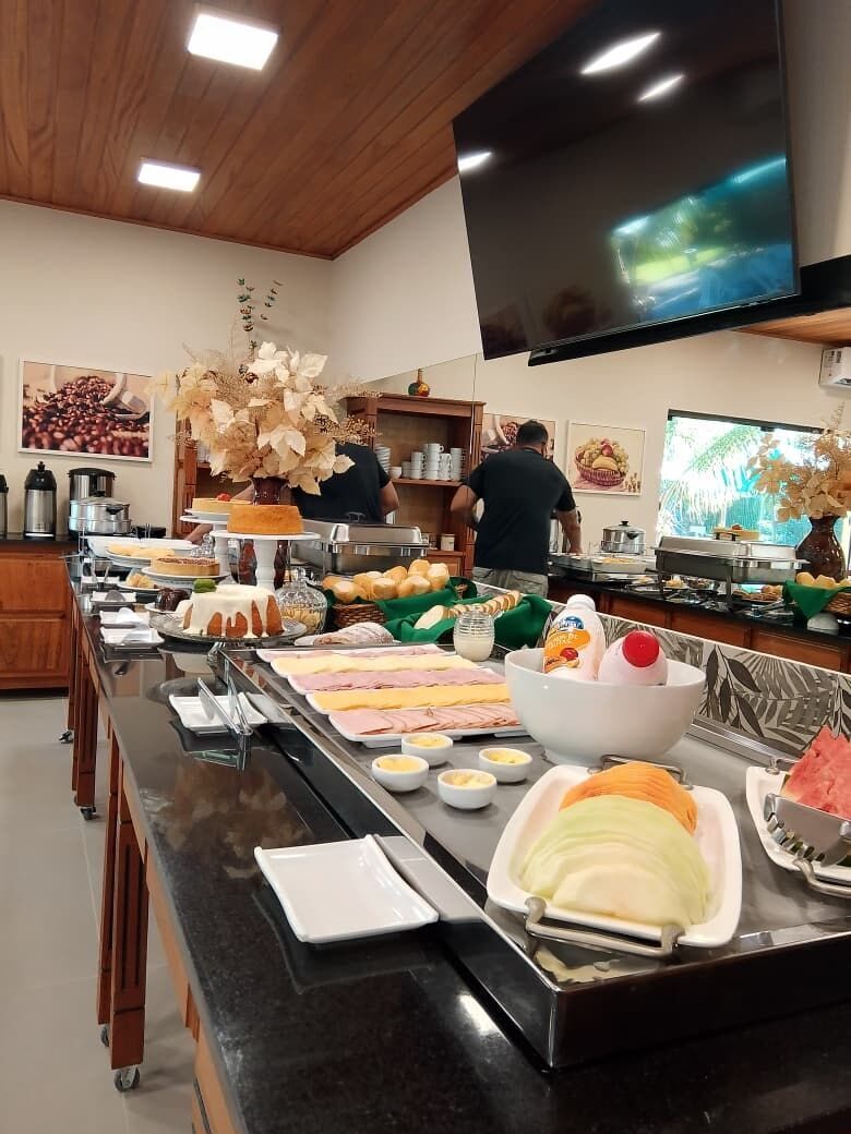 A buffet setup with various food items and a television mounted on the wall.