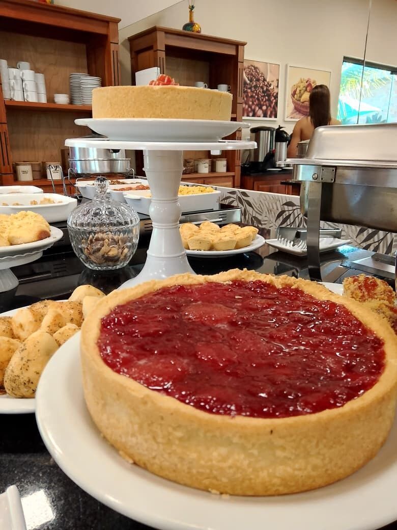 A buffet table with various food items including a large pie, bread, and other baked goods.