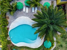 Una piscina al aire libre, sombrillas, sillones reclinables de piscina