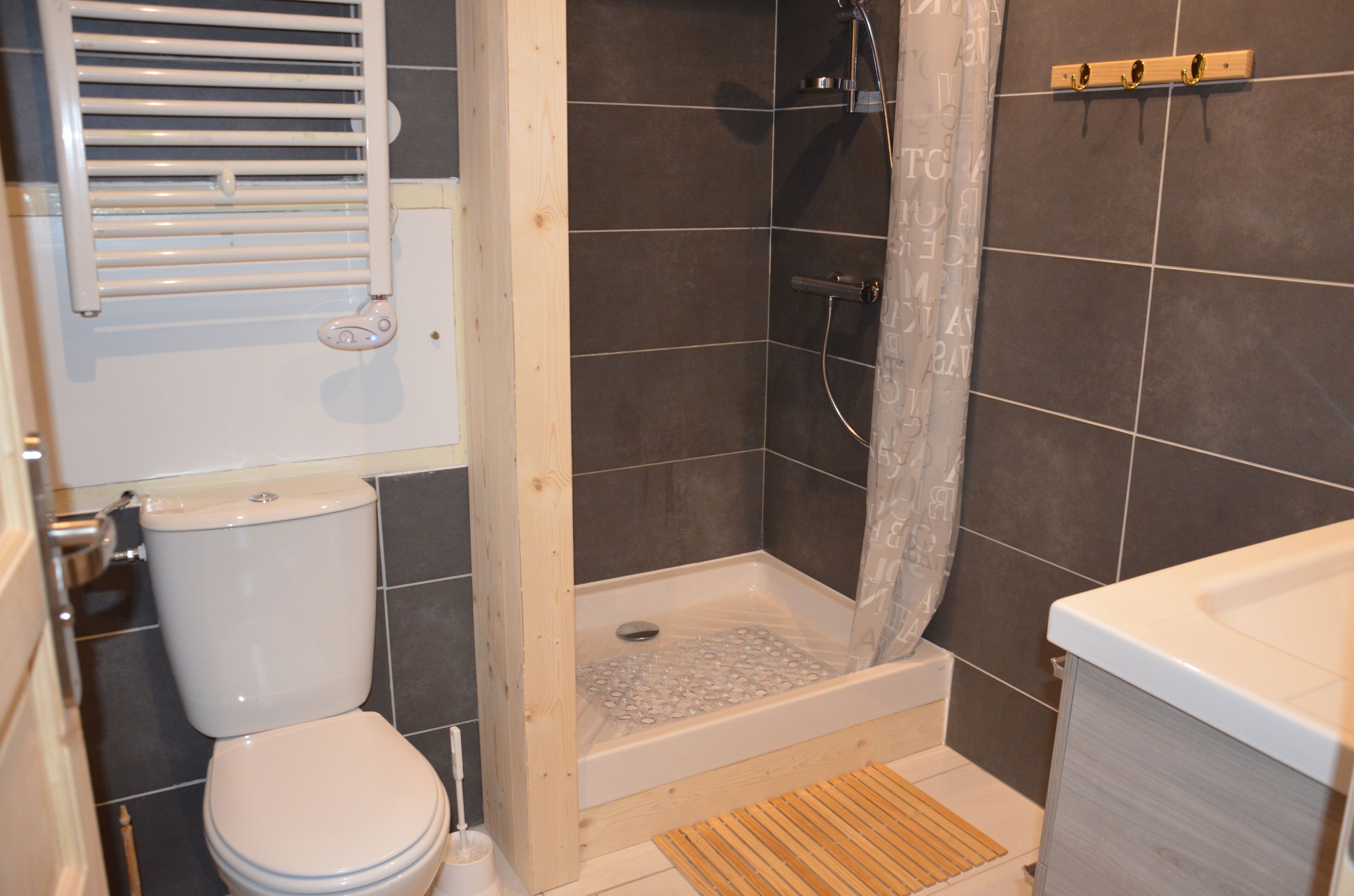 Une salle de bain avec douche, toilettes et baignoire.