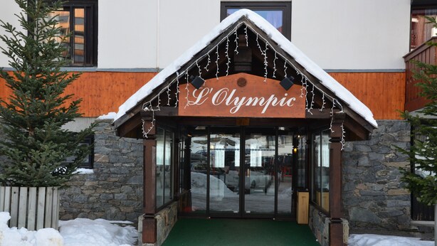 En hotellentrén med en skylt där det står ”L’Olympic”.