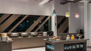 A modern kitchen with a buffet setup, including various dishes and utensils.