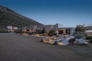 A modern building with stone architecture, a paved pathway, and outdoor lighting.