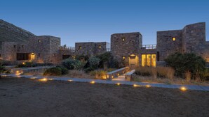 A stone building with multiple towers and a pathway leading to a door.