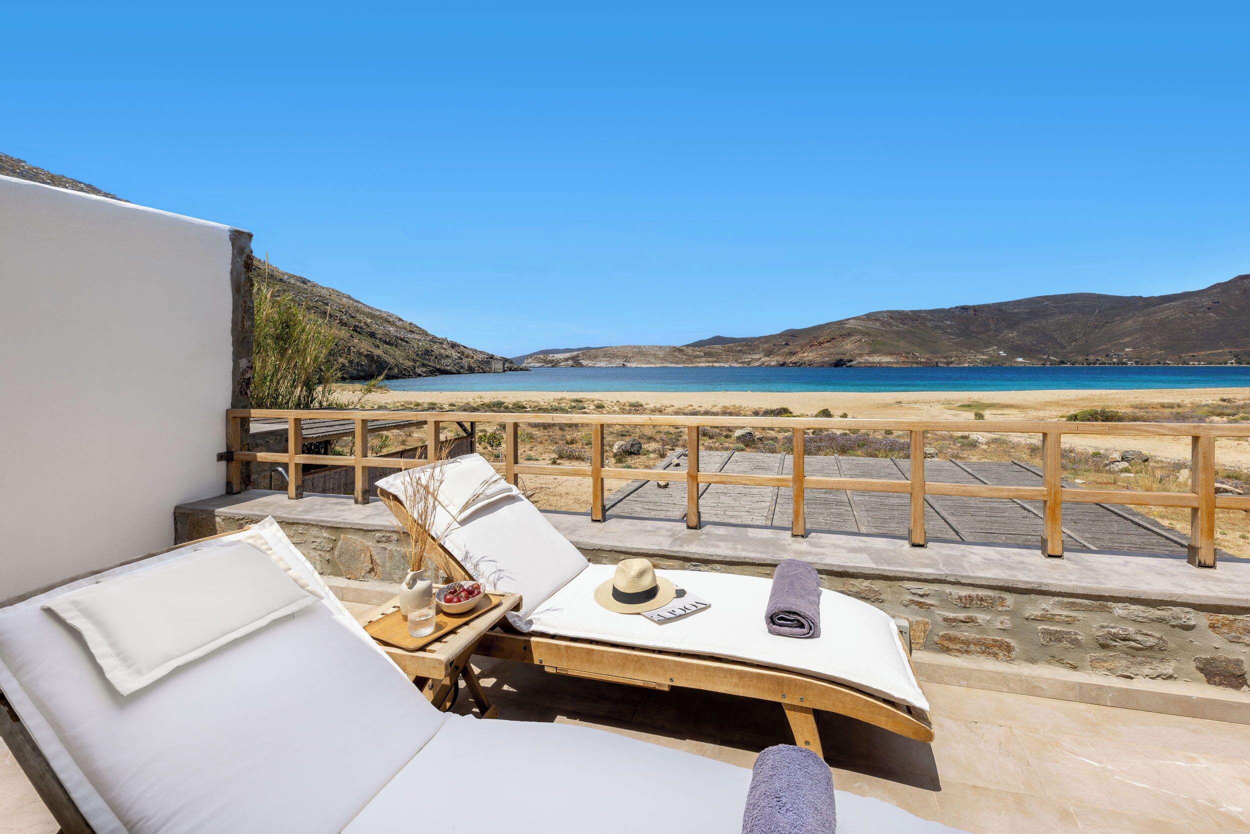 A sun lounger with a view of a beach and mountains.