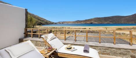 A sun lounger with a view of a beach and mountains.
