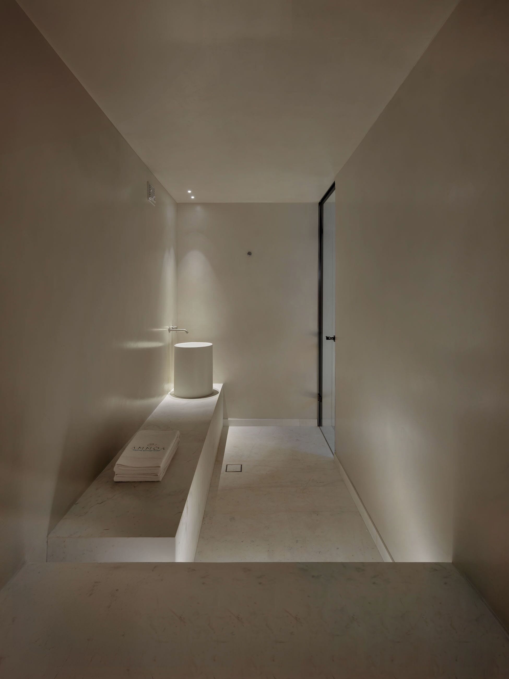 A minimalist bathroom with a large mirror, a towel, and a sink.