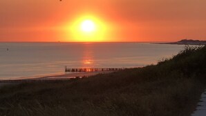 Un atardecer sobre una zona costera con un muelle que se adentra en el agua.