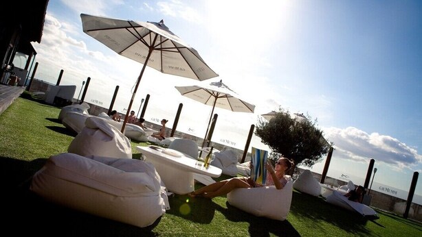 A poolside area with lounge chairs and umbrellas, a grassy lawn, and a view of the sea. - Cozy apartment with sea views, Playa del Cura, Jardin Paraiso  (MOGAN)